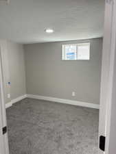 Basement featuring carpet flooring, a textured ceiling, and recessed lighting