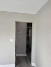 Corridor featuring baseboards and light wood-style floors