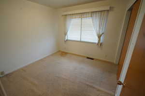 Unfurnished bedroom featuring light colored carpet and a closet
