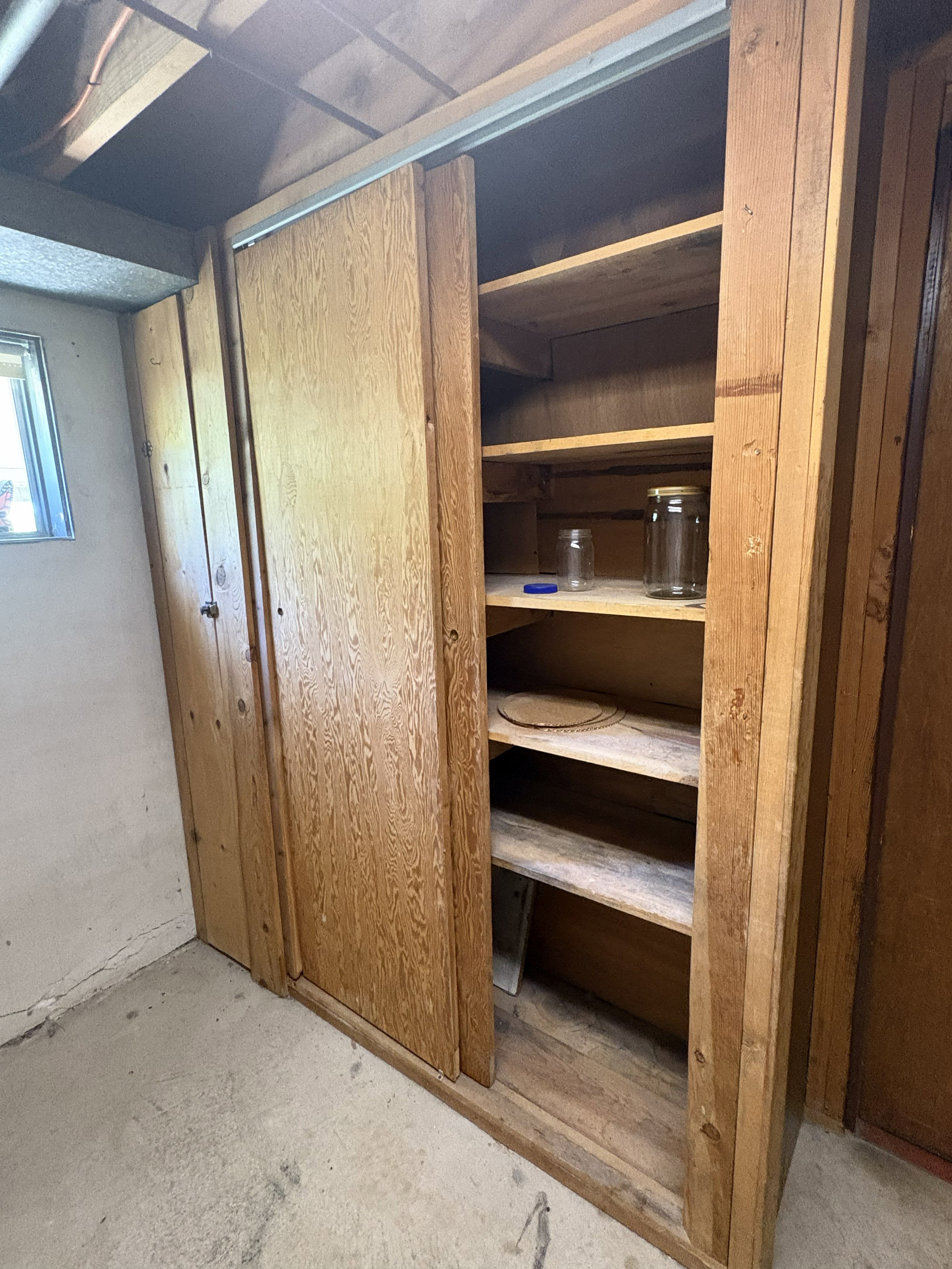 Wood-paneled storage cabinetry with sliding doors and interior shelving