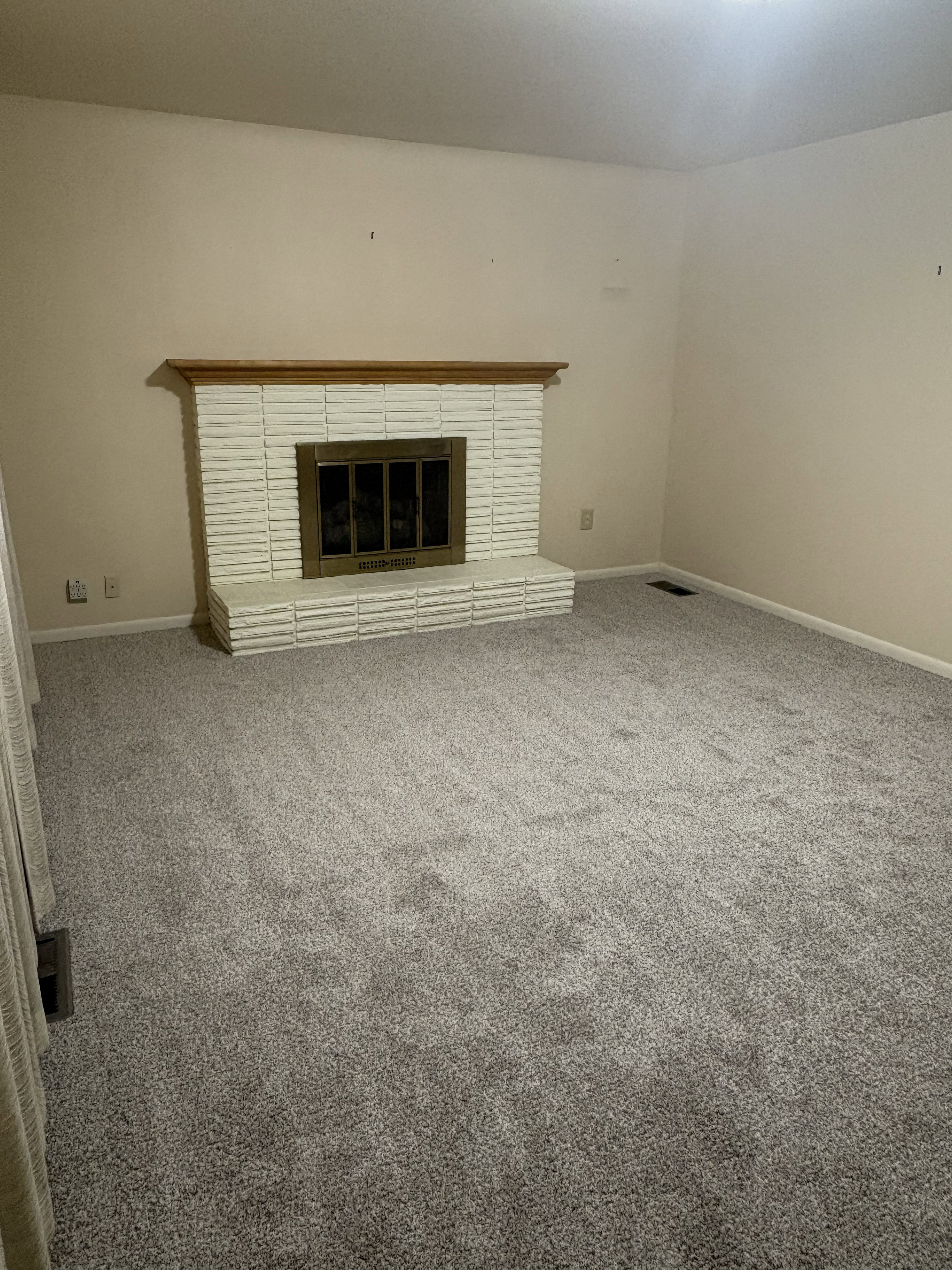 White painted brick fireplace with a wood mantel