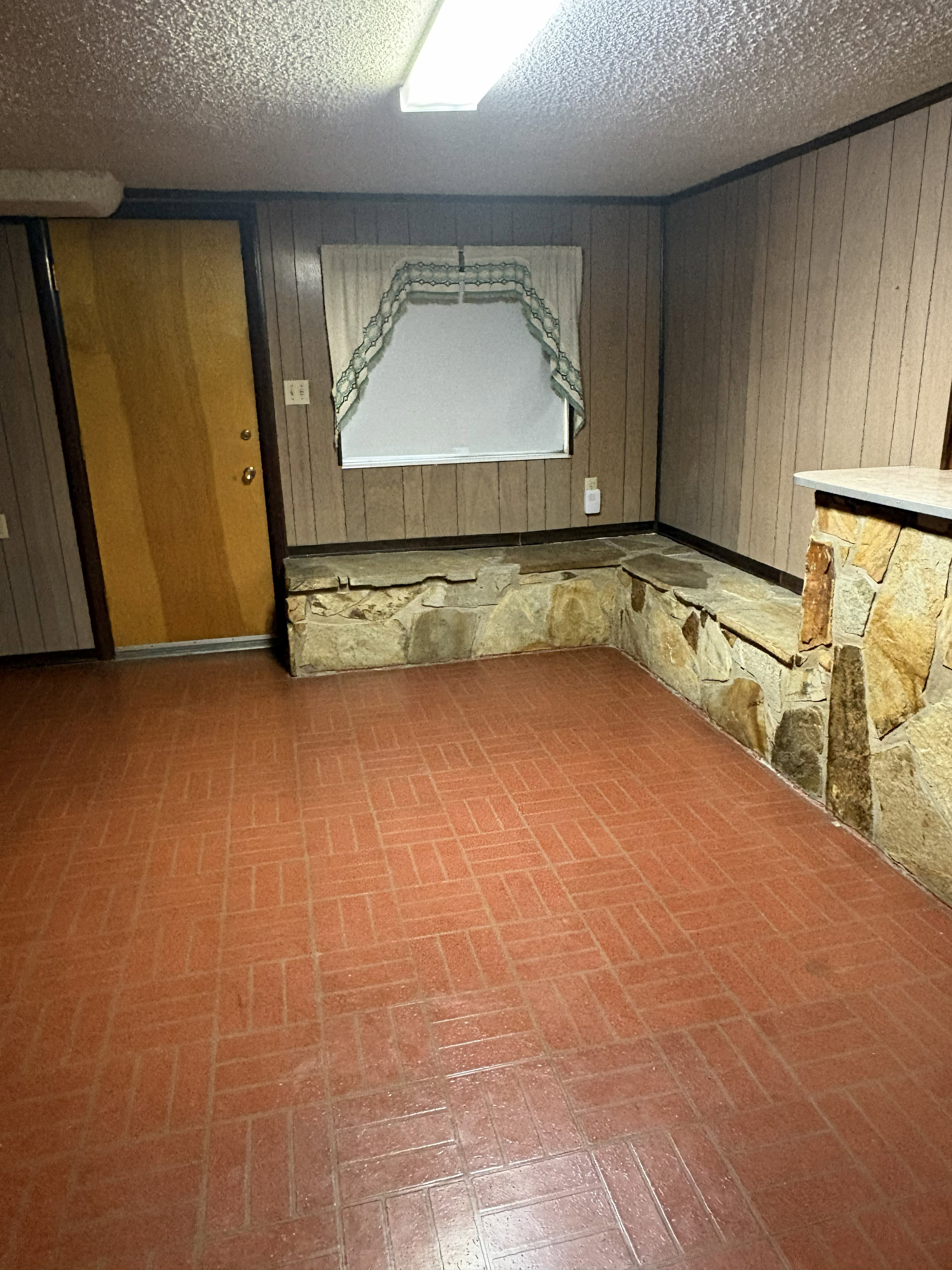 Paneling walls featuring a window with a valance