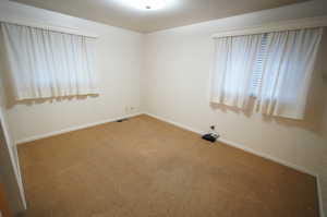 Carpeted spare room with baseboards