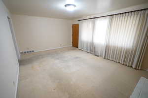 Unfurnished room with light carpet and baseboards