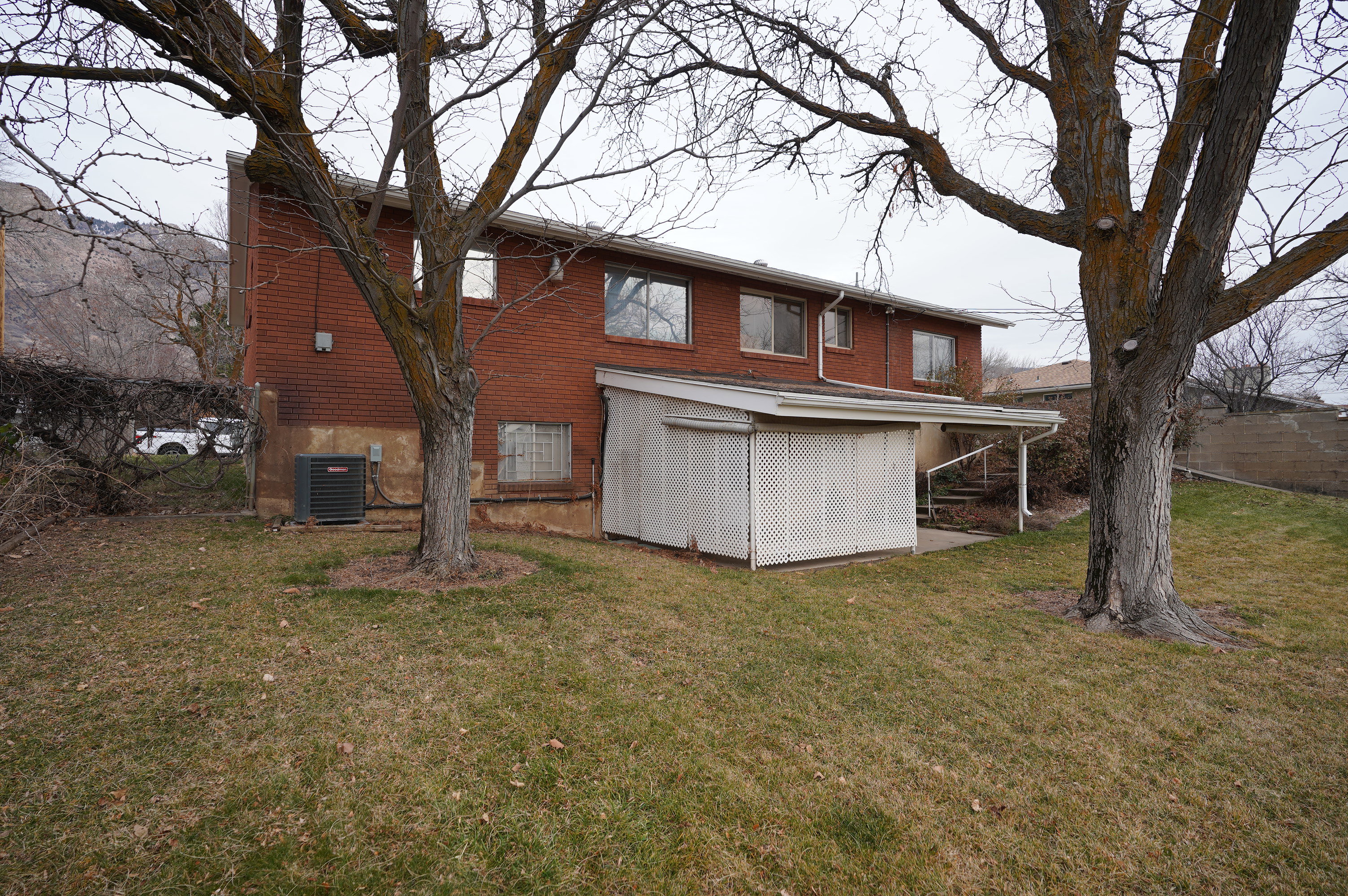 Rear view of property featuring a lawn and brick siding