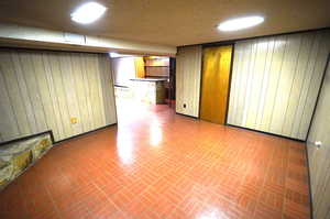 Finished below grade area with wooden walls and brick patterned flooring
