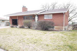 Single story home with a front lawn, brick siding, a chimney, and a shingled roof