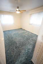 Unfurnished room featuring carpet and ceiling fan