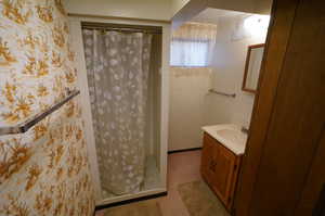Bathroom featuring a shower stall and vanity