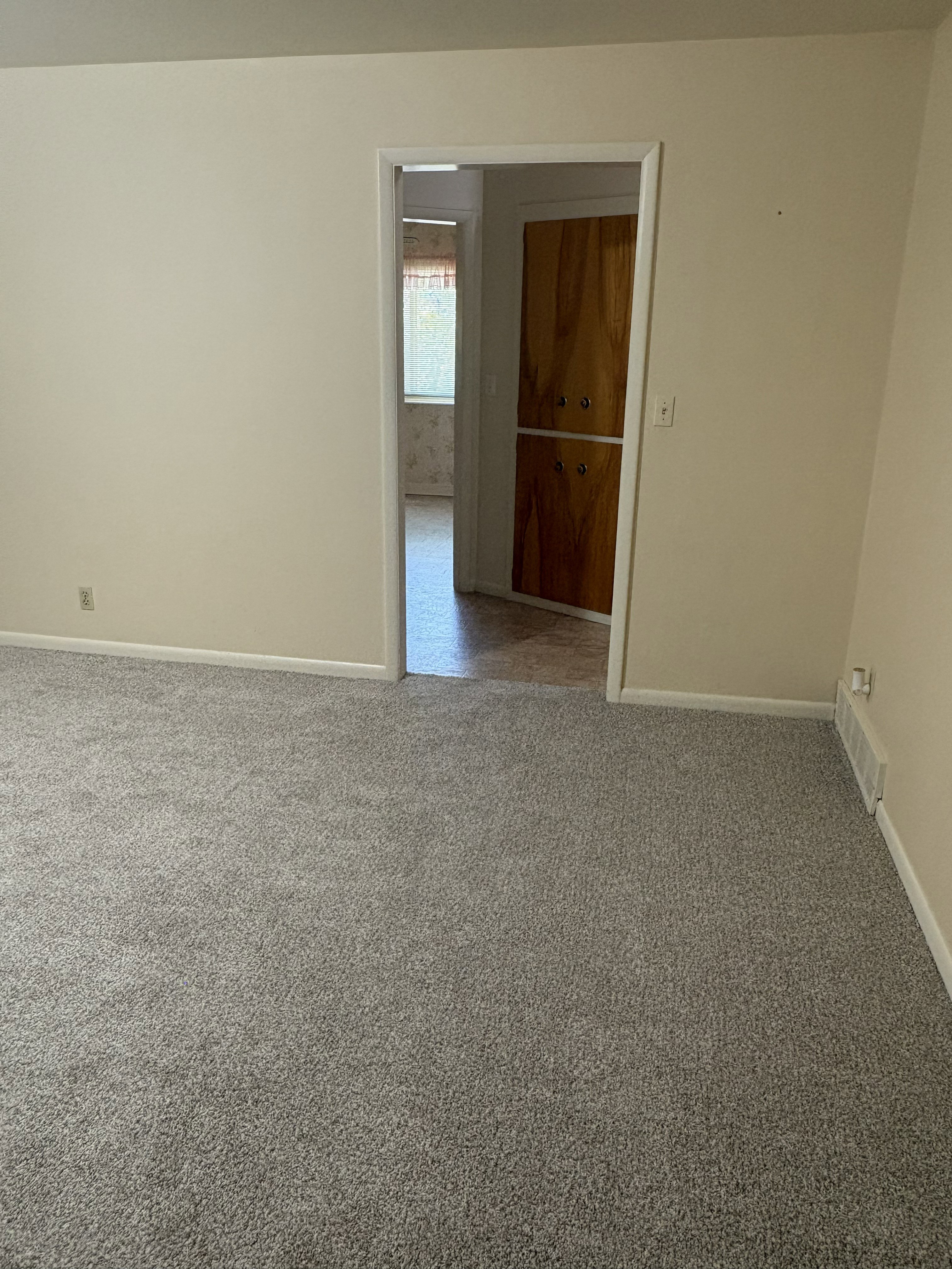 Neutral-toned walls complement the gray carpeting