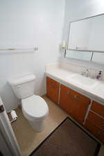 Bathroom with vanity and dark aggregate flooring