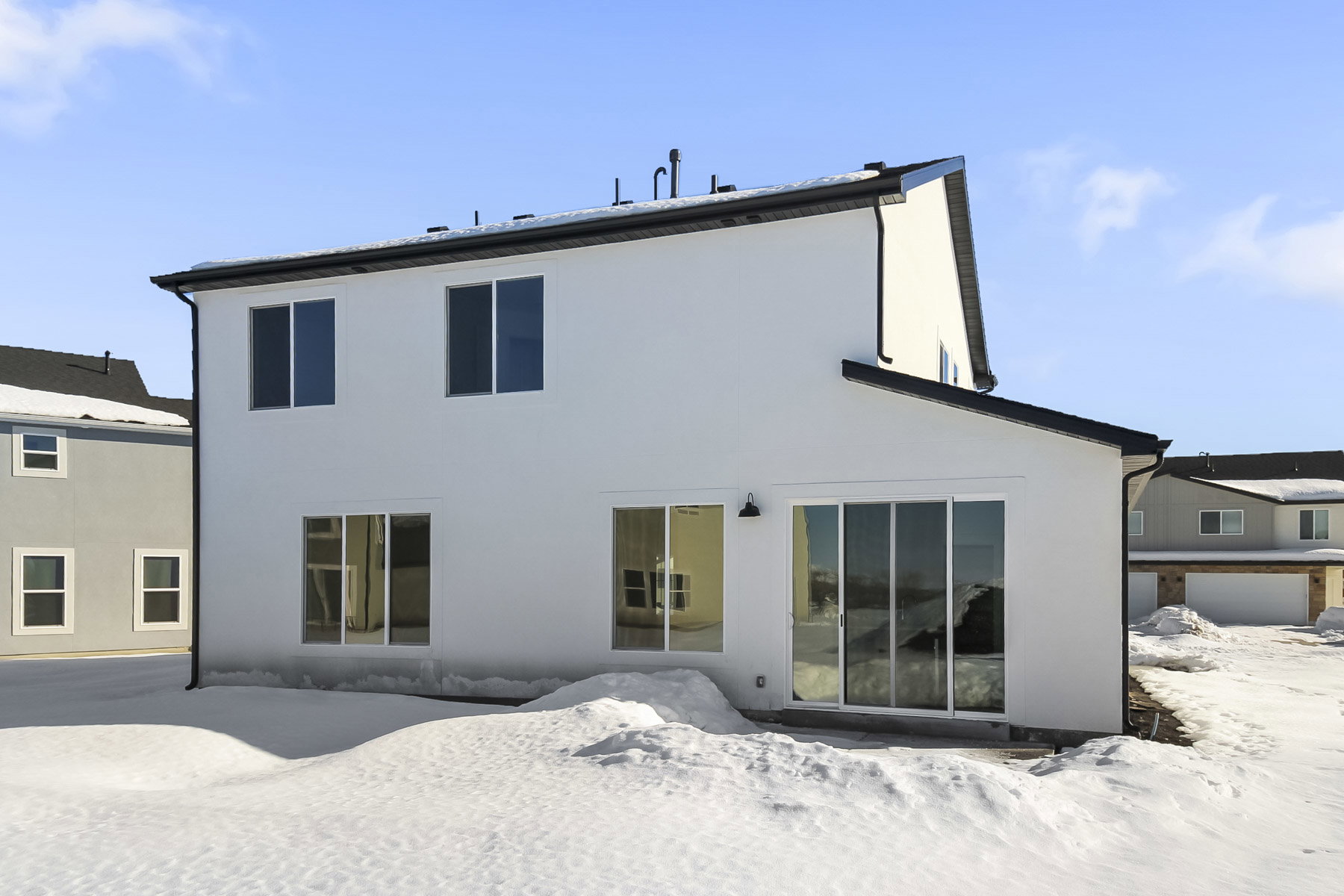 Snow covered house with stucco siding