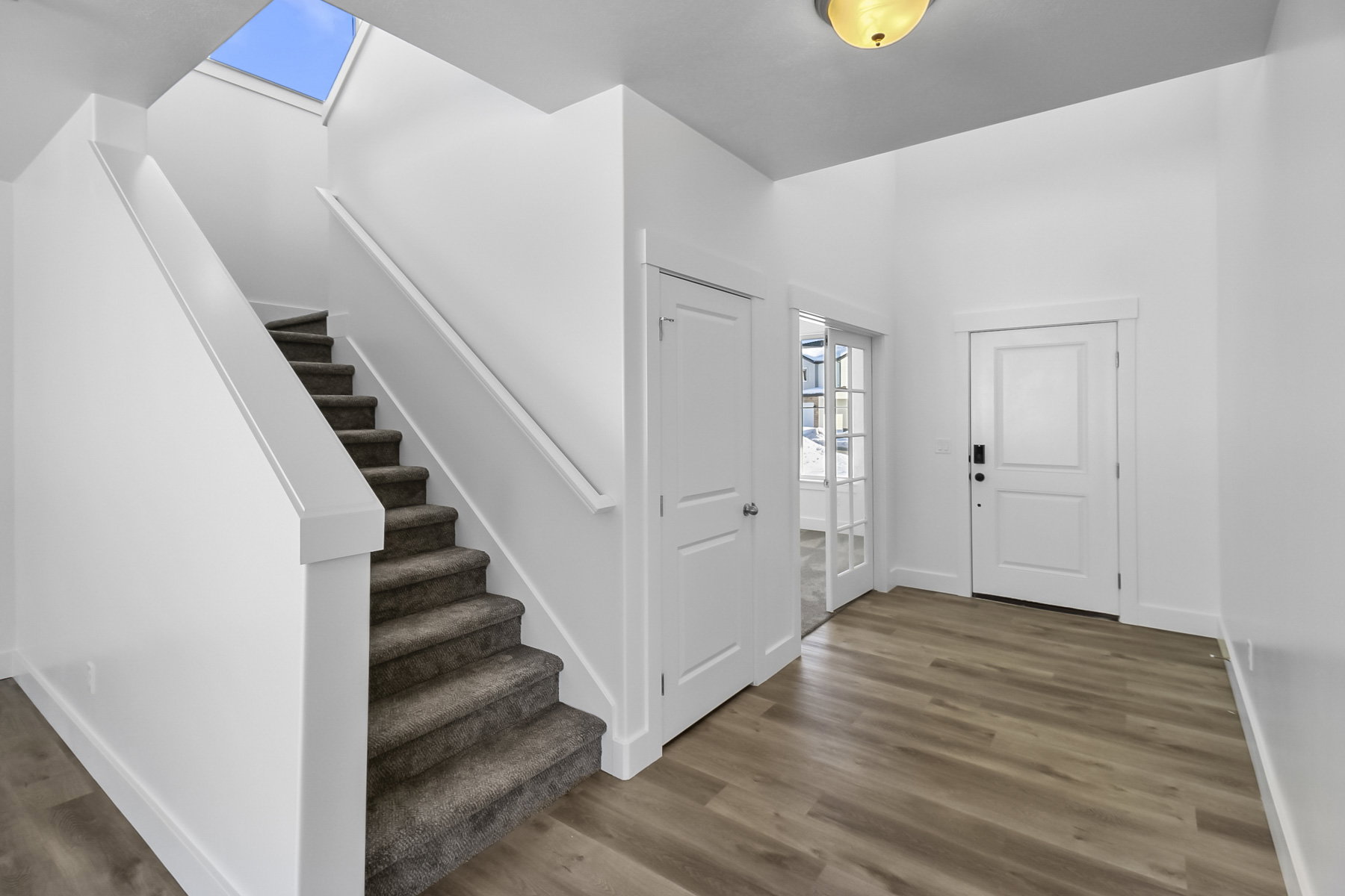 Entryway featuring wood finished floors and a skylight