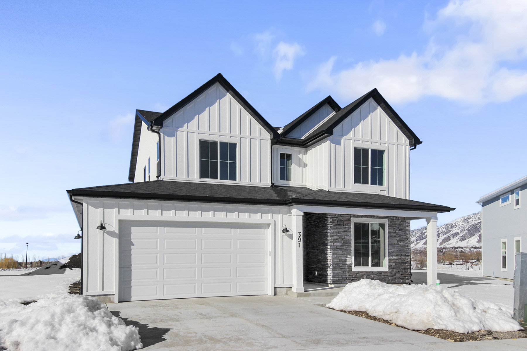Modern farmhouse with board and batten siding, a garage, concrete driveway, and a shingled roof