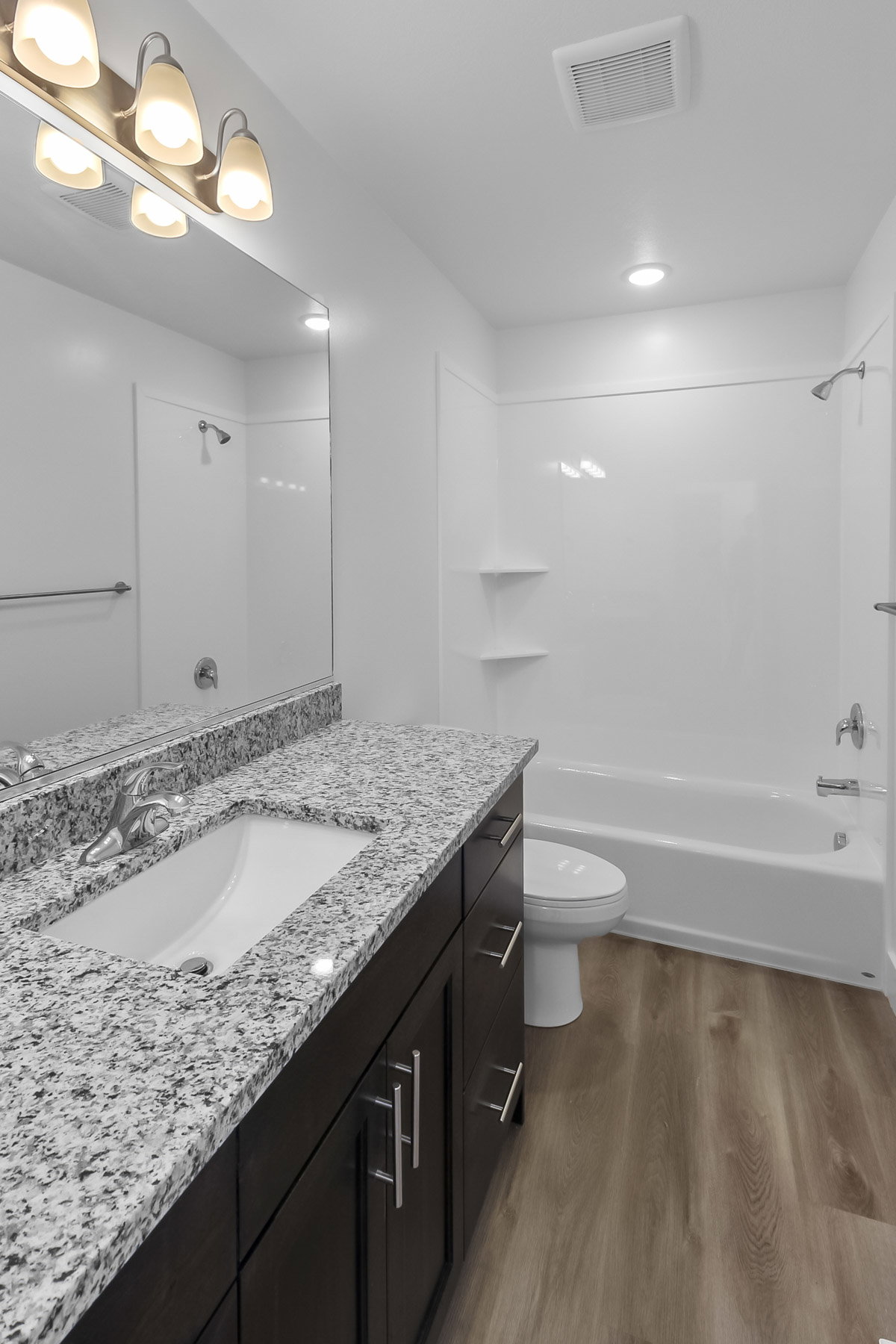 Full bathroom featuring vanity, washtub / shower combination, and dark wood-style floors