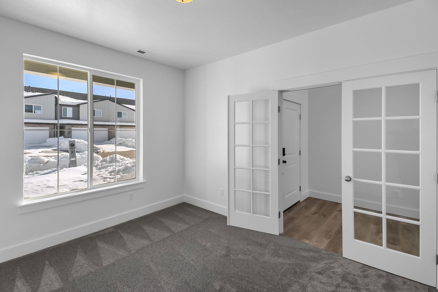 Unfurnished room featuring dark colored carpet and french doors
