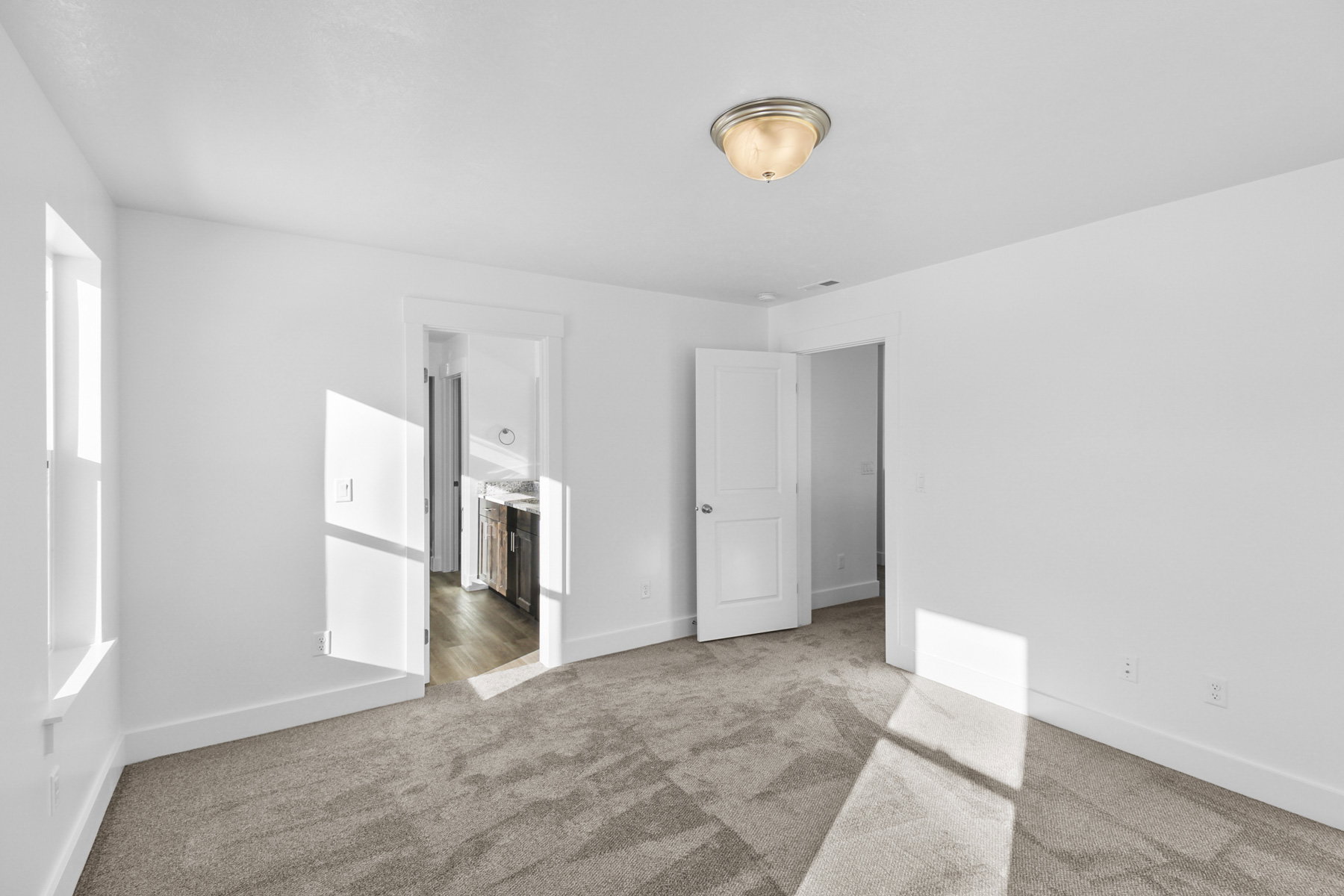 Unfurnished bedroom with light colored carpet and baseboards