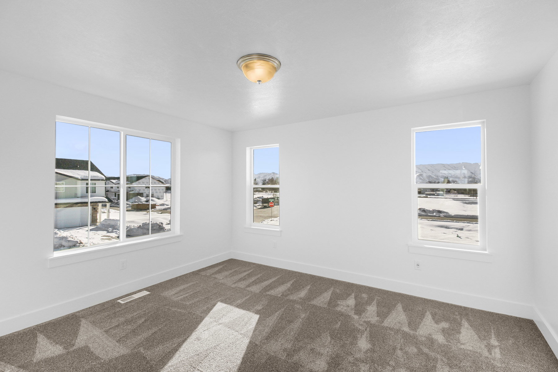 Spare room featuring baseboards and dark carpet