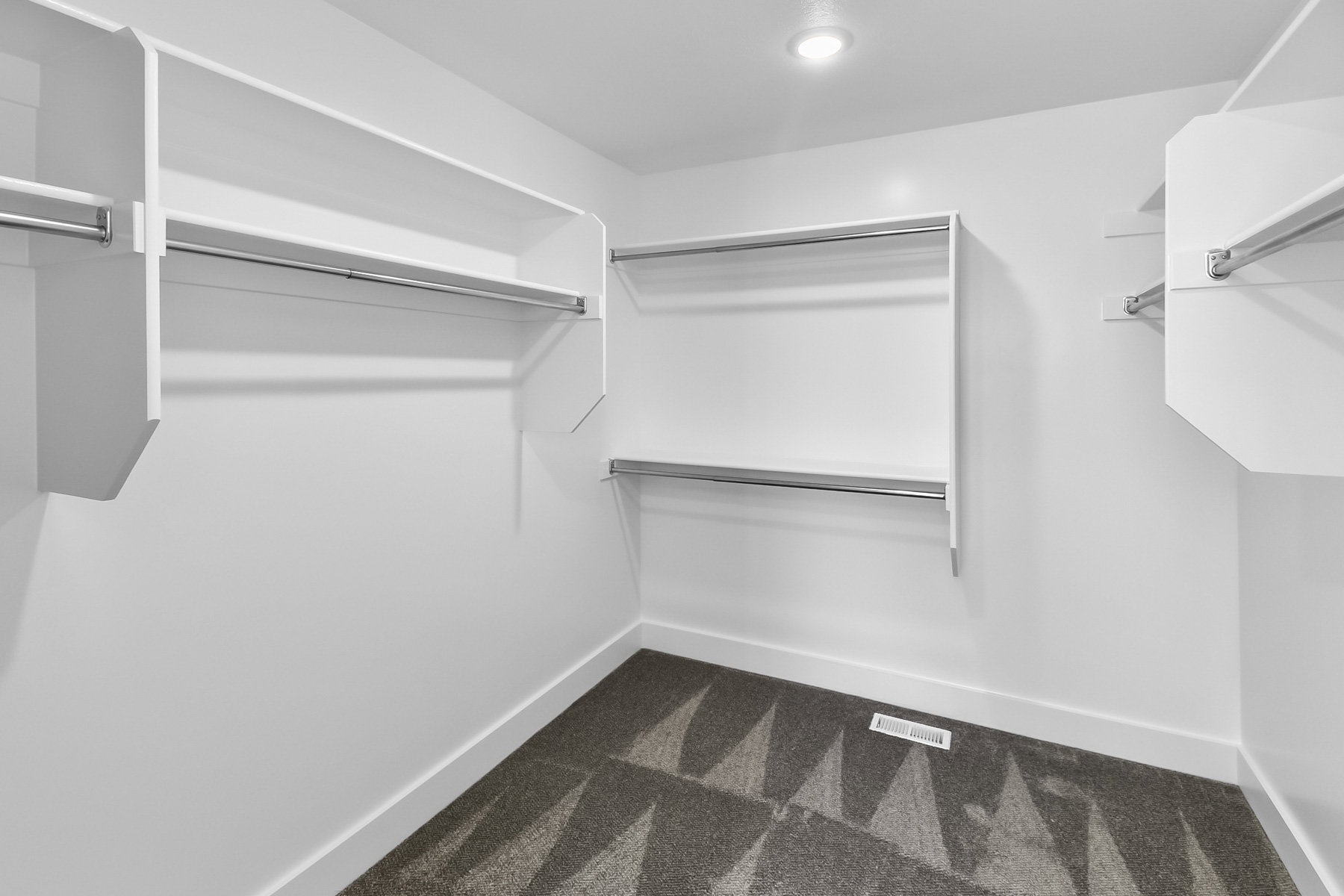 Walk in closet with dark colored carpet