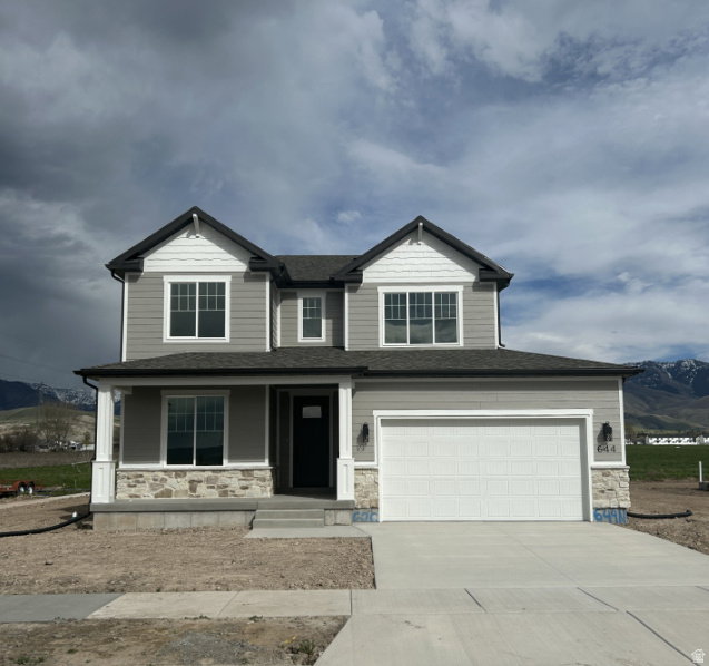 Two-story residence featuring light gray siding with white trim accents and dark gray roofing