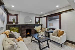 Living room with a fireplace, wood finished floors, and recessed lighting