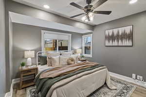 Bedroom with wood finished floors, a ceiling fan, and recessed lighting