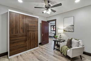 Living area featuring light wood-style flooring, a ceiling fan, and recessed lighting