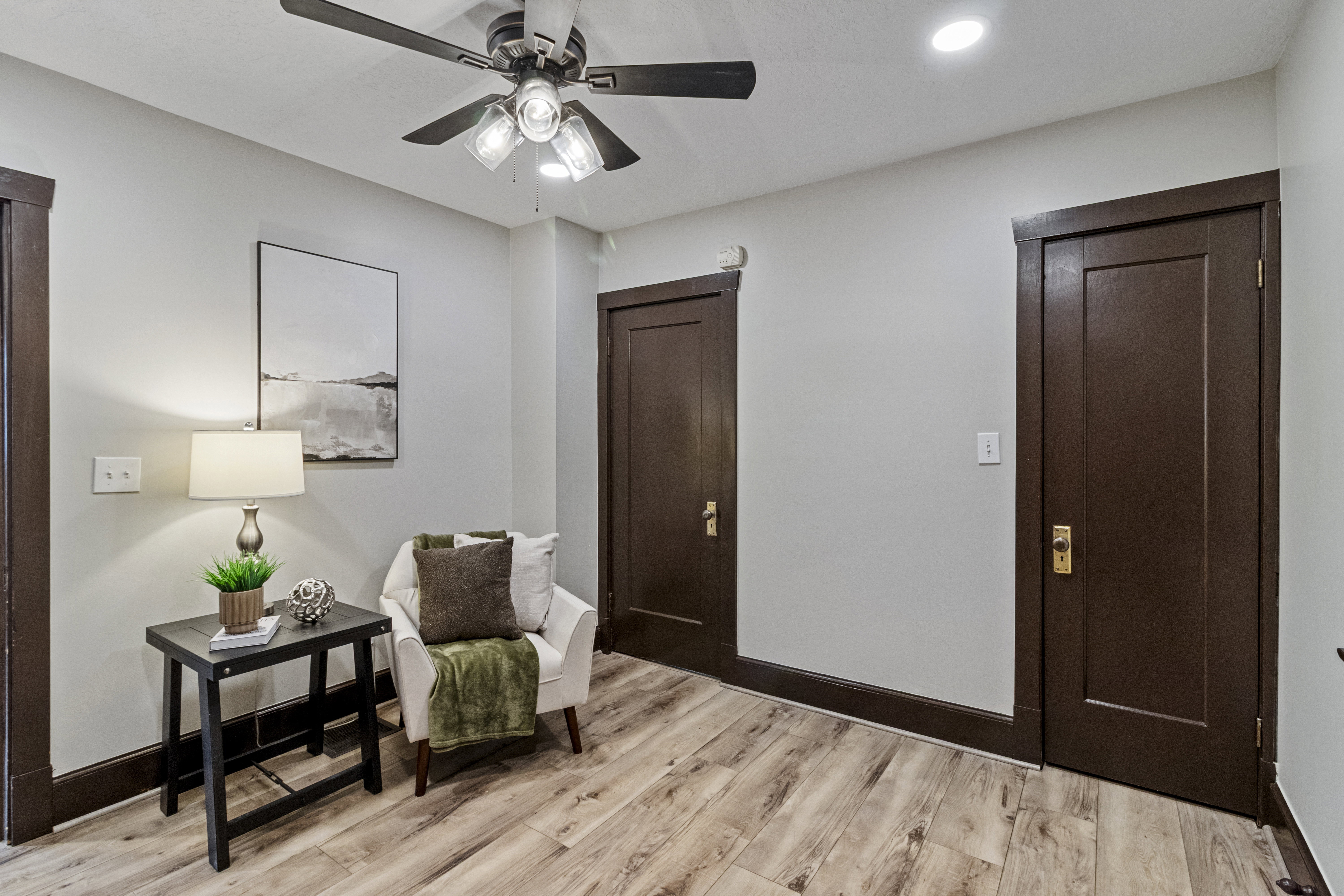 Living area with light wood-type flooring and a ceiling fan