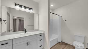 Bathroom with vanity, light wood-style flooring, and shower / bath combo with shower curtain