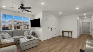 Living room featuring wood finished floors, ceiling fan, and recessed lighting