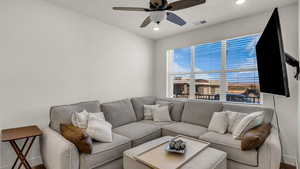 Living area with a ceiling fan and recessed lighting