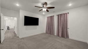 Spare room with light colored carpet and a ceiling fan