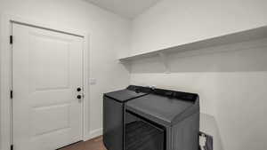 Laundry room with dark wood-style flooring and washer and clothes dryer