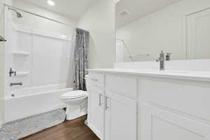 Full bathroom featuring vanity, dark wood-style floors, and shower / bath combo with shower curtain