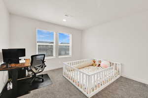 Bedroom with an office area, carpet floors, and a nursery area