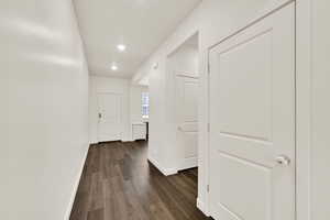Hall with dark wood-style flooring and recessed lighting