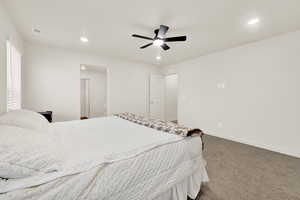 Bedroom with light carpet, ceiling fan, and recessed lighting
