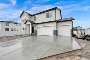 View of front of home with a garage, driveway, and board and batten siding