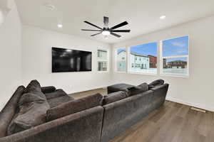 Living room with wood finished floors, ceiling fan, and recessed lighting