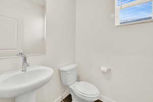 Half bath with toilet and baseboards