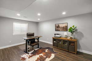Office area featuring dark wood-type flooring and recessed lighting