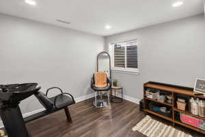 Living area with dark wood-type flooring and recessed lighting