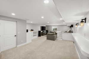 Living room with light colored carpet and recessed lighting