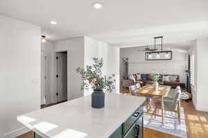 Kitchen featuring a center island, green cabinetry, dark wood-style flooring, a ceiling fan, and vaulted ceiling