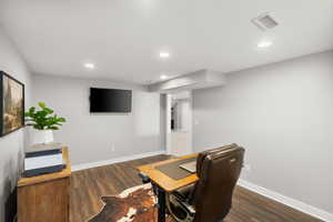 Sitting room featuring a desk, dark wood-style flooring, and recessed lighting