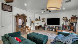 Living room featuring ceiling fan, wood finished floors, and recessed lighting