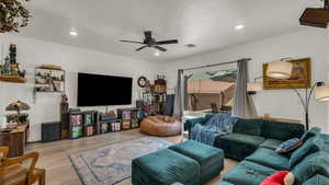 Living room featuring wood finished floors, a ceiling fan, and recessed lighting