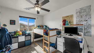 Bedroom with an office area, carpet, and ceiling fan