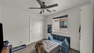 Living area featuring ceiling fan and carpet
