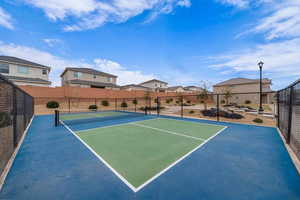 View of tennis court with a residential view
